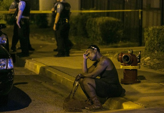 A woman sits on the curb as Chicago police investigate an August scene where gunfire at a birthday party left a man dead and a woman injured. (Credit: Ashlee Rezin/Chicago Sun-Times)
